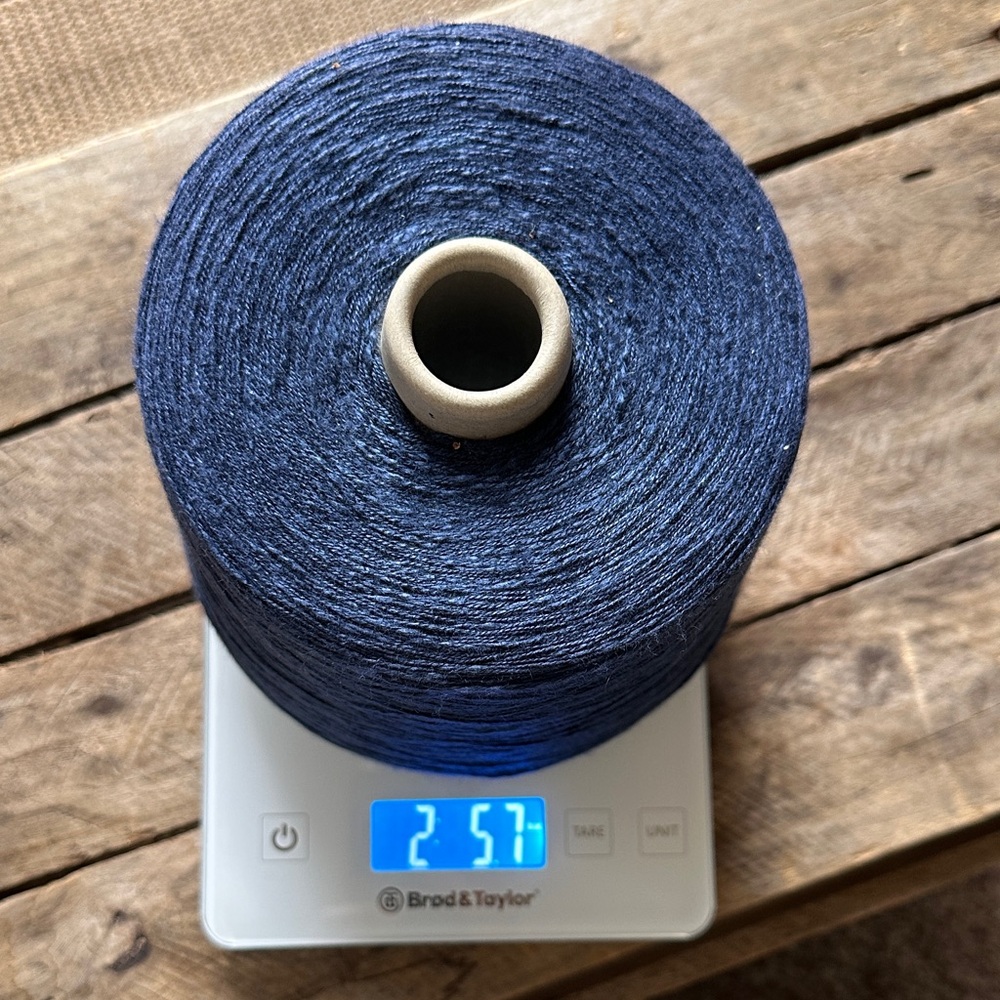 Bright navy blue slub rayon yarn on a cone